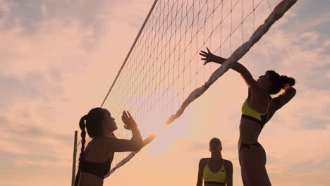 An-Einem-Schönen-Sommerabend-Springt-Ein-Sportliches-Mädchen-Beim-Beachvolleyball-In-Die-Luft-Und-Schlägt-Den-Ball-über-Das-Netz.-Eine-Kaukasische-Frau-Erzielt-Einen-Punkt.